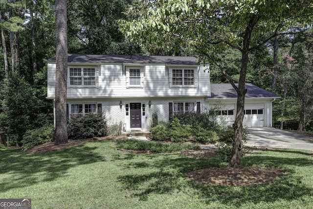 colonial house featuring a garage, a front yard, brick siding, and driveway