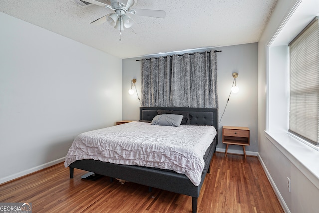 bedroom featuring ceiling fan, a textured ceiling, and hardwood / wood-style floors