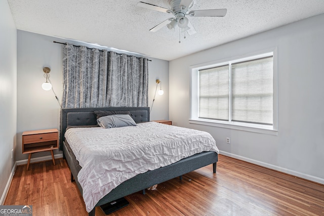 bedroom featuring ceiling fan, a textured ceiling, and wood-type flooring