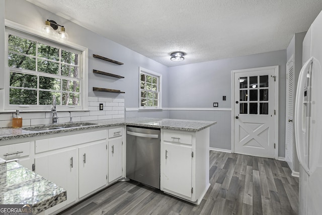 kitchen featuring a sink, white cabinets, wainscoting, dishwasher, and open shelves