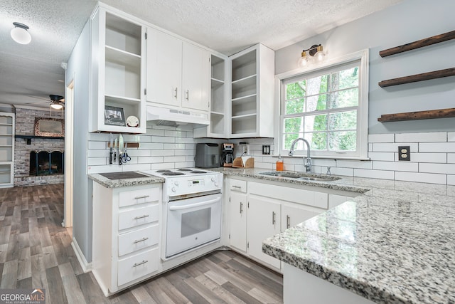 kitchen featuring a fireplace, a textured ceiling, white range, and premium range hood