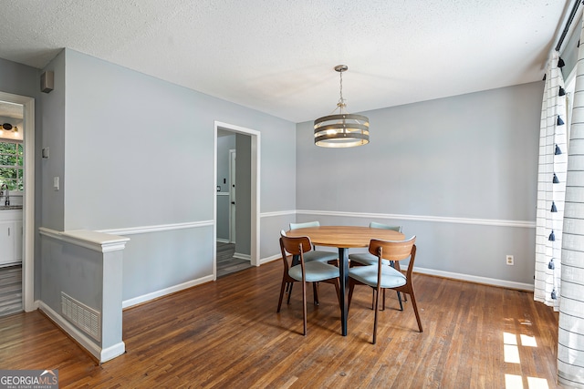 dining space with hardwood / wood-style flooring and a textured ceiling