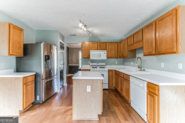 kitchen featuring light hardwood / wood-style flooring, sink, track lighting, a kitchen island, and white appliances