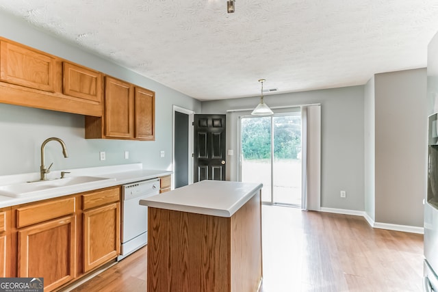 kitchen featuring light hardwood / wood-style flooring, hanging light fixtures, white dishwasher, sink, and a center island