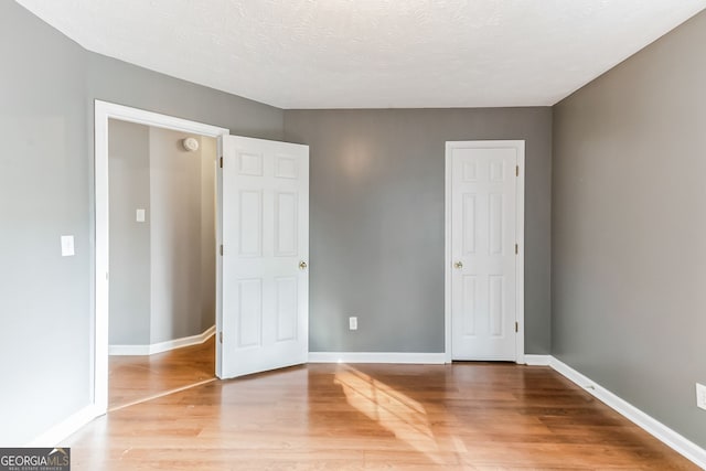 unfurnished bedroom with hardwood / wood-style flooring