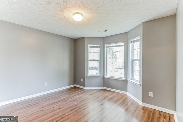 spare room with hardwood / wood-style floors and a textured ceiling