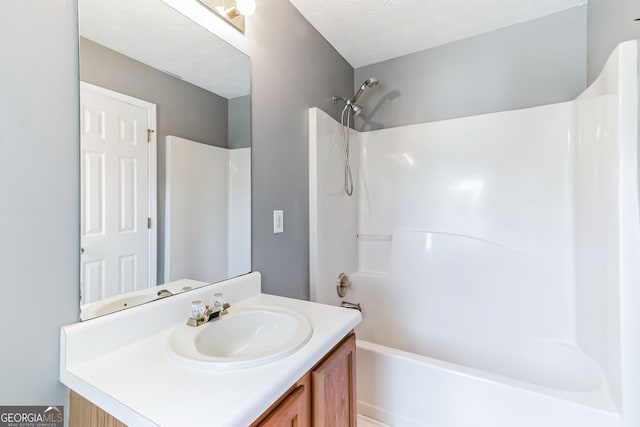 bathroom featuring shower / tub combination, vanity, and a textured ceiling