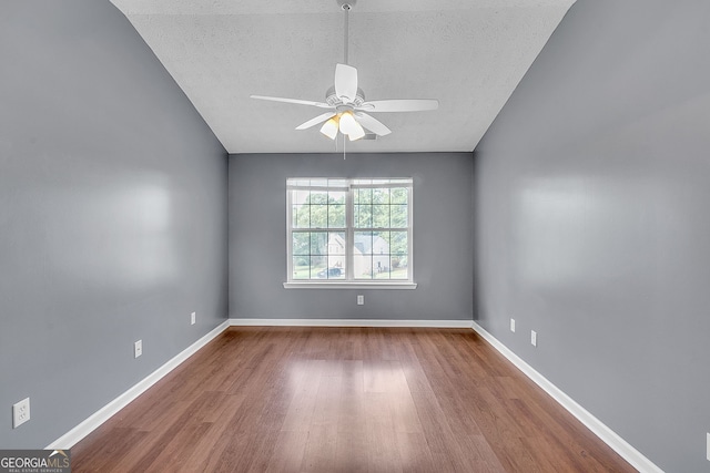 spare room featuring ceiling fan, lofted ceiling, and wood-type flooring