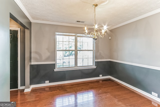 unfurnished room featuring hardwood / wood-style flooring, ornamental molding, a textured ceiling, and a chandelier