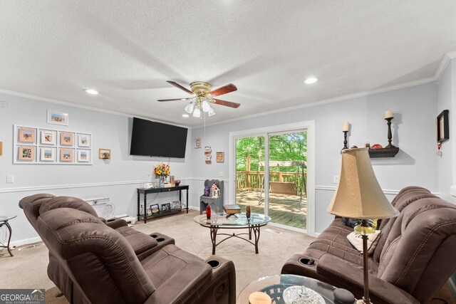 carpeted living room with a textured ceiling, ceiling fan, and ornamental molding