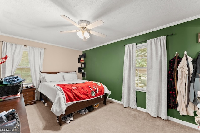 carpeted bedroom with ceiling fan, a textured ceiling, baseboards, and ornamental molding