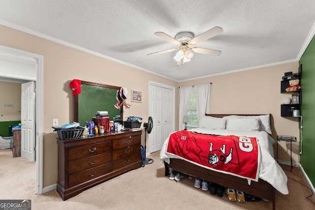 carpeted bedroom with ceiling fan, ornamental molding, a closet, and a textured ceiling