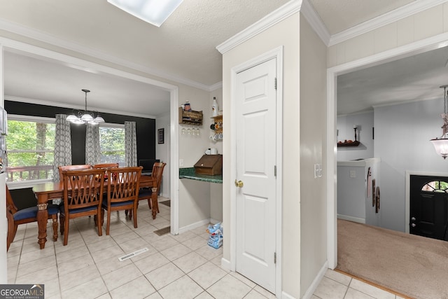 dining room featuring light tile patterned floors, crown molding, a notable chandelier, and a textured ceiling