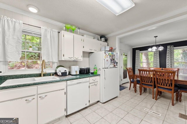 kitchen with white appliances, ornamental molding, a sink, white cabinetry, and dark countertops