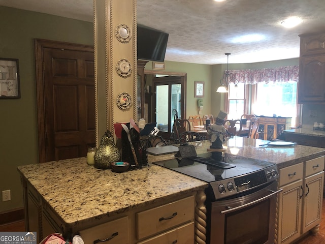 kitchen with light stone countertops, electric range, a kitchen island, and a textured ceiling