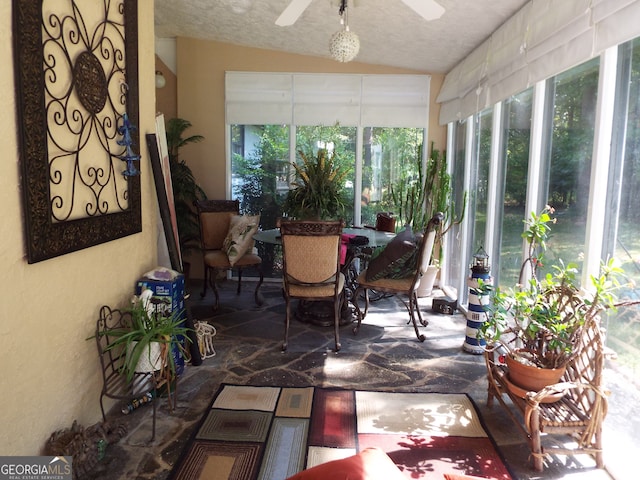 sunroom / solarium with a healthy amount of sunlight, ceiling fan, and vaulted ceiling