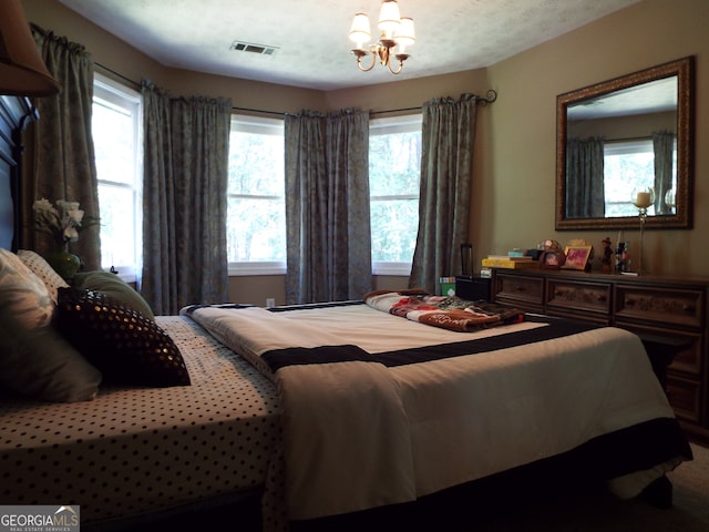 bedroom featuring an inviting chandelier and a textured ceiling