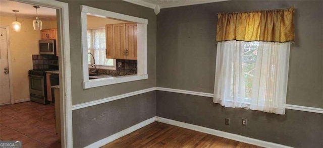 unfurnished dining area with sink, ornamental molding, and tile patterned flooring