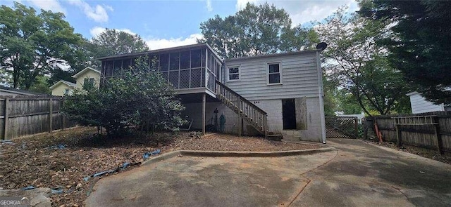 back of property with a sunroom and a patio