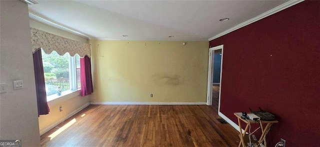 empty room featuring hardwood / wood-style flooring and crown molding