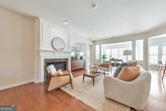 living area featuring baseboards, light wood finished floors, and a premium fireplace