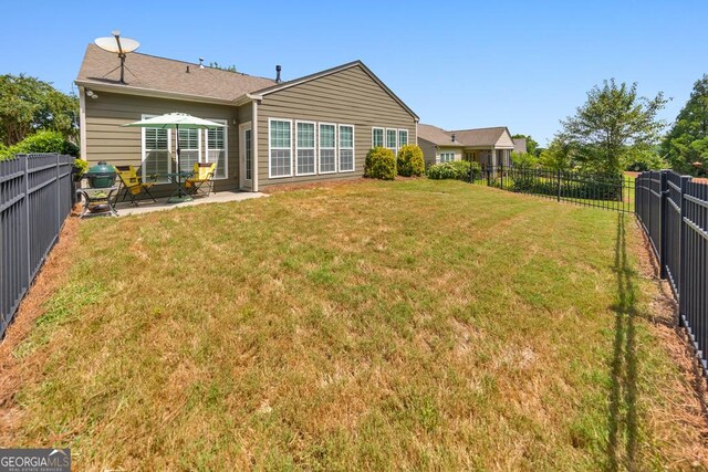 back of property with a yard and a patio area