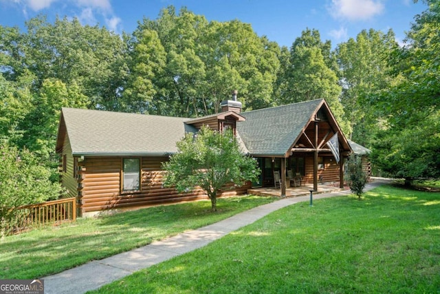 log cabin with a front lawn