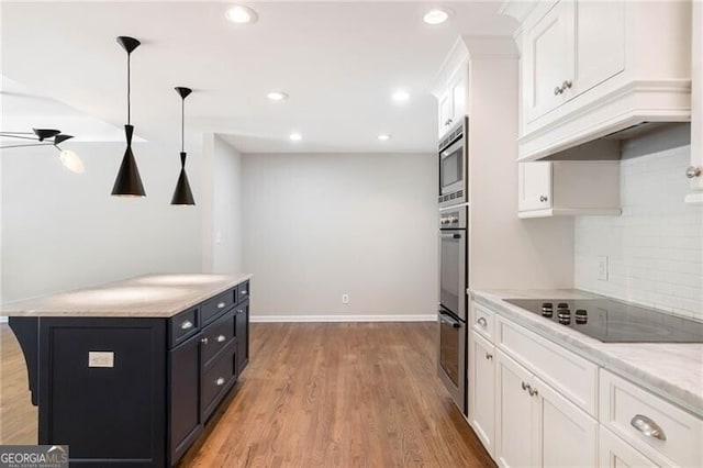 kitchen featuring light hardwood / wood-style flooring, tasteful backsplash, hanging light fixtures, white cabinetry, and stainless steel appliances