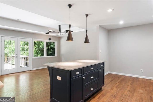 kitchen with light hardwood / wood-style flooring, french doors, and decorative light fixtures