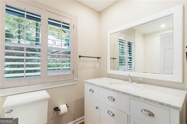 bathroom with plenty of natural light, toilet, and vanity