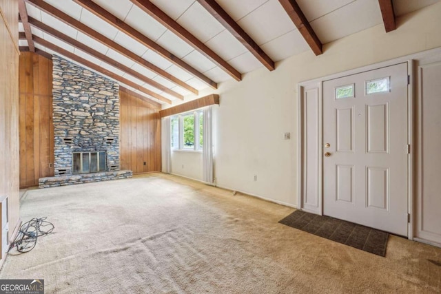 entrance foyer with a fireplace, vaulted ceiling with beams, wood walls, and carpet