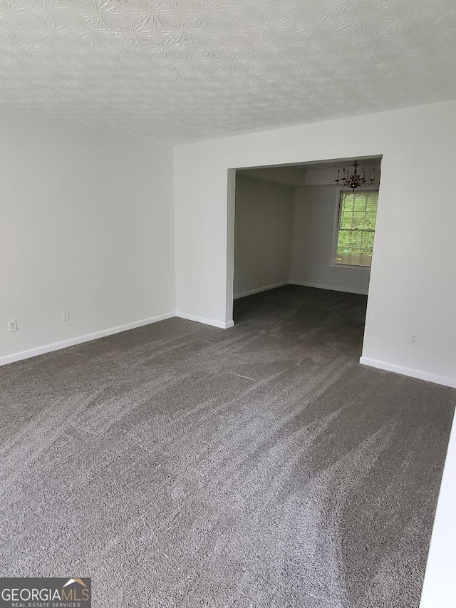 spare room featuring a textured ceiling and carpet flooring