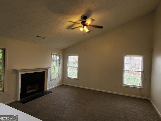 unfurnished living room with ceiling fan, dark carpet, and vaulted ceiling