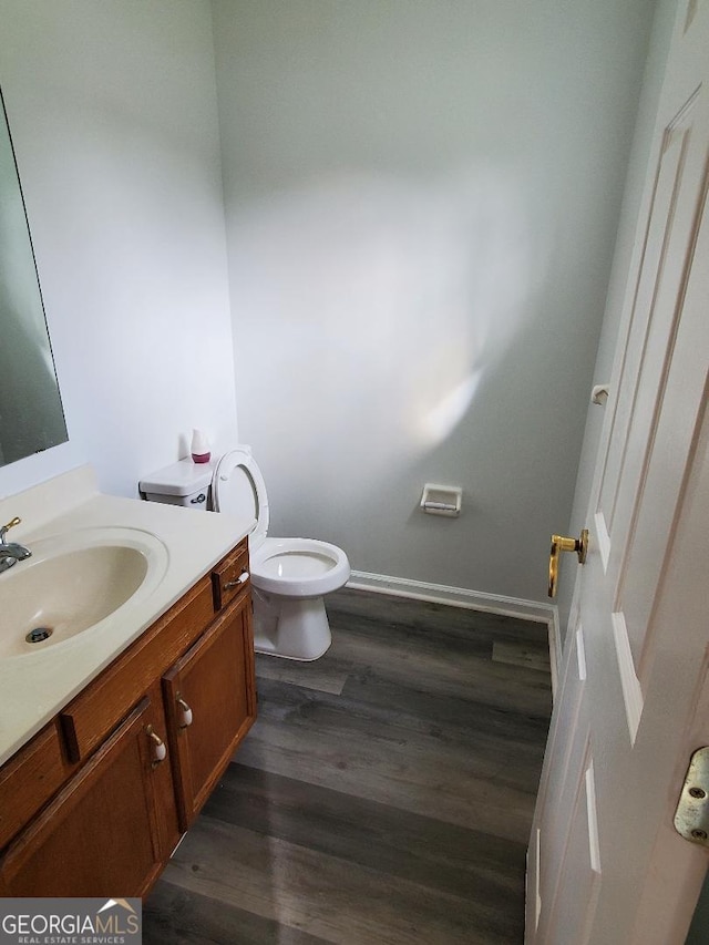 bathroom featuring toilet, vanity, and wood-type flooring