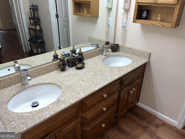 bathroom featuring double vanity, a sink, and wood finished floors