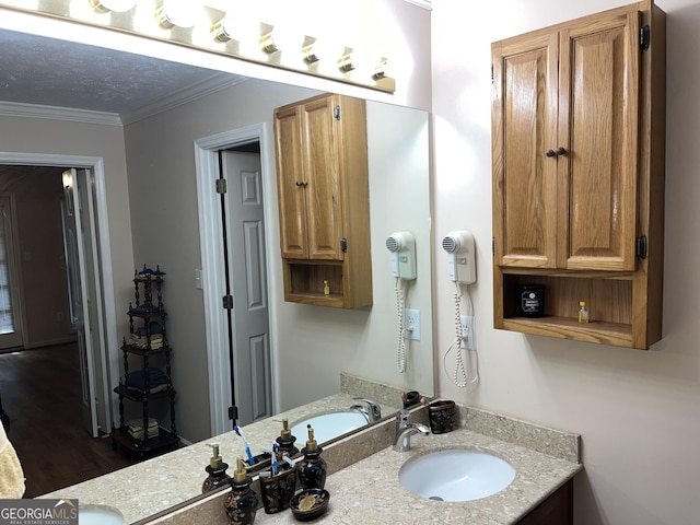 bathroom with crown molding, vanity, a textured ceiling, and wood finished floors