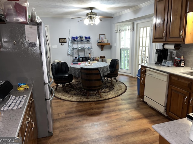 kitchen with light countertops, dark wood-style flooring, white dishwasher, and freestanding refrigerator