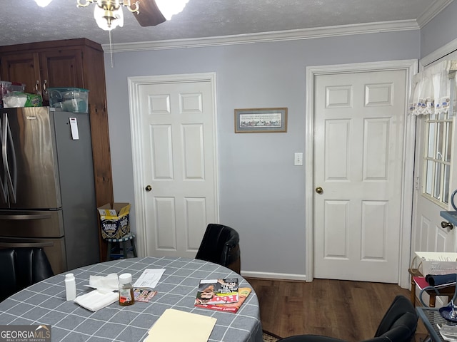 dining room with dark wood-style flooring, crown molding, ceiling fan, a textured ceiling, and baseboards