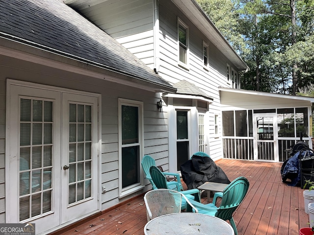 wooden deck with a sunroom and french doors