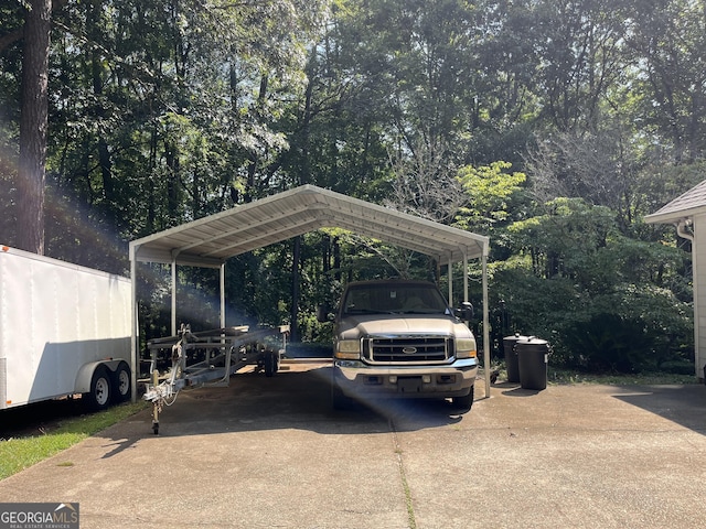 view of vehicle parking with concrete driveway and a carport