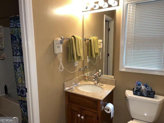 full bathroom with shower / bathtub combination with curtain, vanity, and toilet