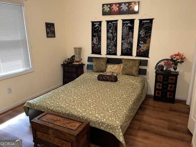 bedroom featuring dark wood-style floors and baseboards