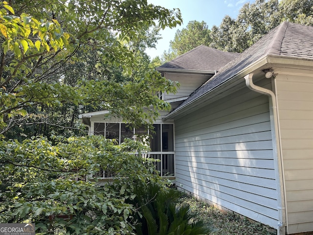 view of side of home with a shingled roof