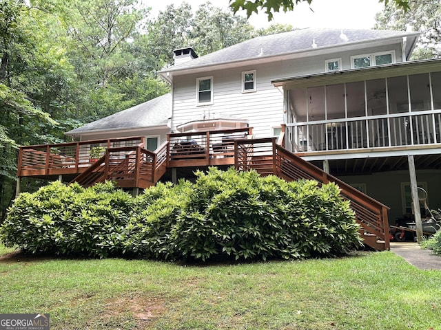 rear view of house featuring a sunroom, a chimney, a wooden deck, and stairs