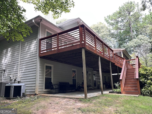 rear view of house with central AC unit, stairs, a wooden deck, a chimney, and a patio area