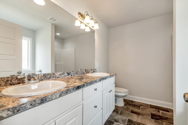 bathroom featuring vanity, toilet, and a shower