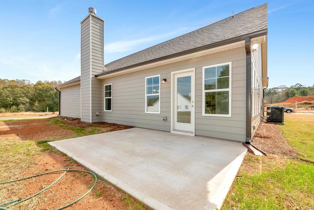 rear view of property with central air condition unit and a patio