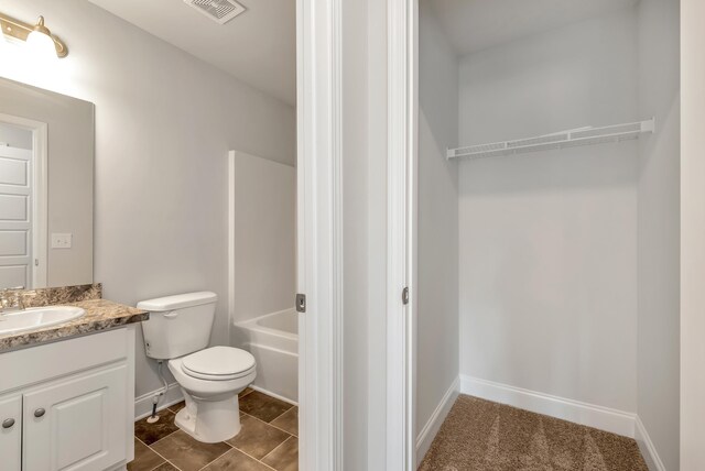 bathroom with tile patterned flooring, vanity, and toilet