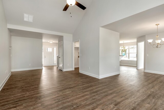 unfurnished living room featuring high vaulted ceiling, dark wood-type flooring, and ceiling fan with notable chandelier