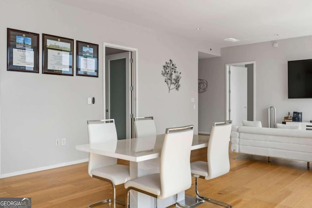 dining area featuring baseboards and light wood-style floors